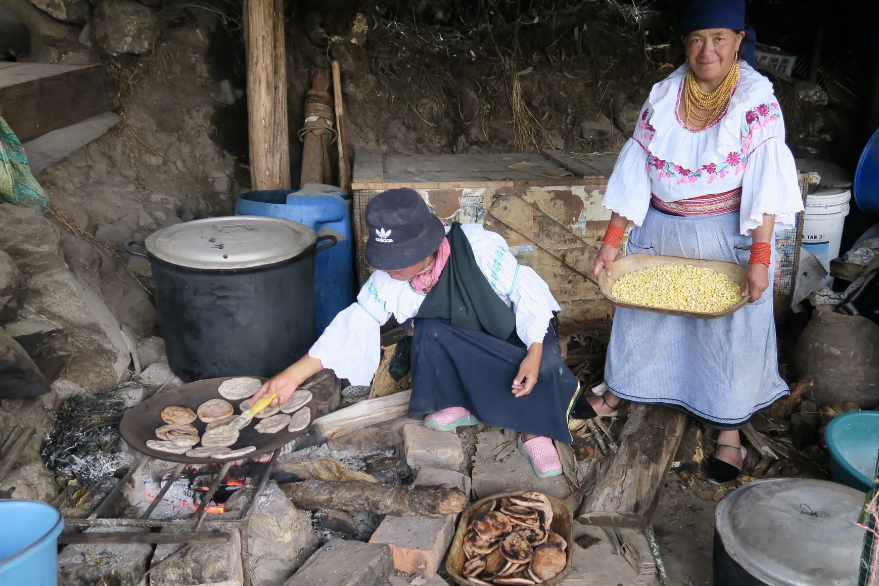 Mãe e filha, Dona Josefa e María Dolores, estão na foto torrando milho e fazendo tortillas em uma tulpa tradicional (fogão a lenha).